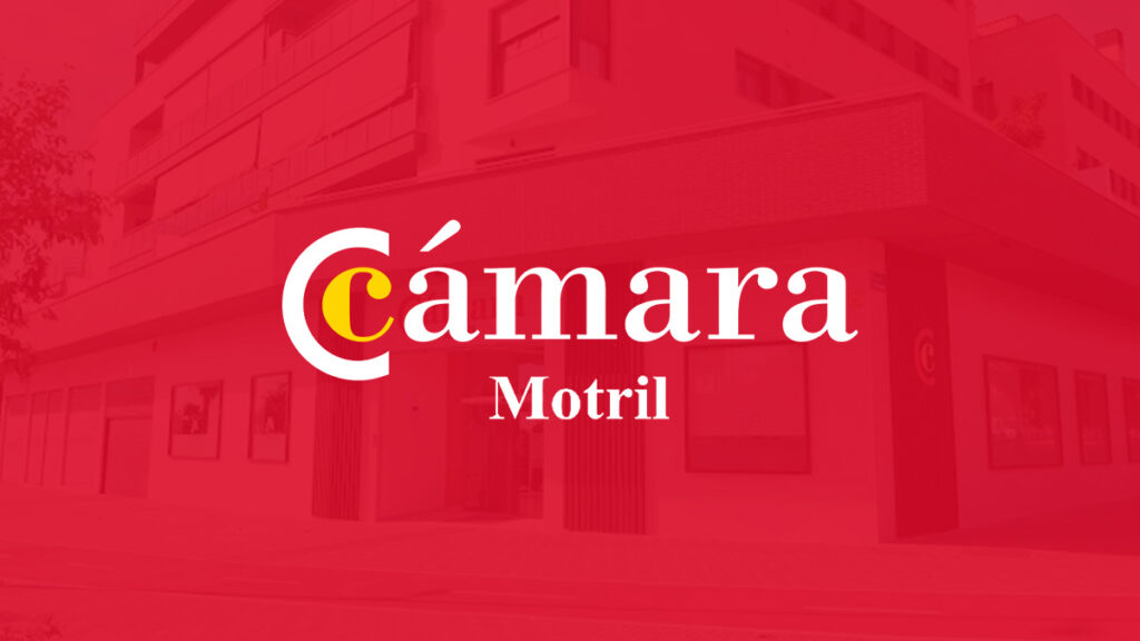 Fachada del local de la Cámara de Comercio de Motril bajo un fondo rojo con transferencia y su logotipo